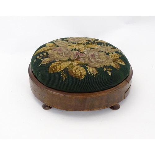 273 - A 19thC circular needlework footstool with an inset upholstered seat and a walnut frame raised on sq... 