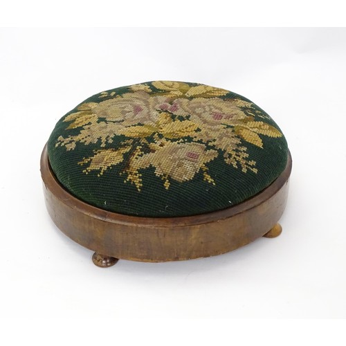 273 - A 19thC circular needlework footstool with an inset upholstered seat and a walnut frame raised on sq... 