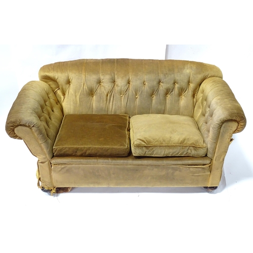 343 - A Victorian two seater button back sofa, with drop-end mechanism to each arm. Measuring approx 68