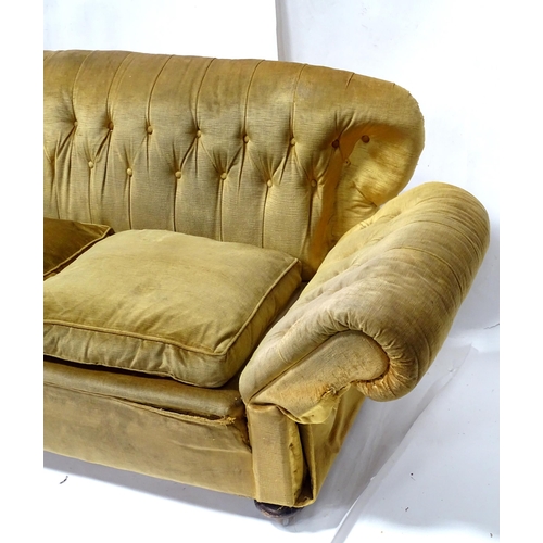 343 - A Victorian two seater button back sofa, with drop-end mechanism to each arm. Measuring approx 68