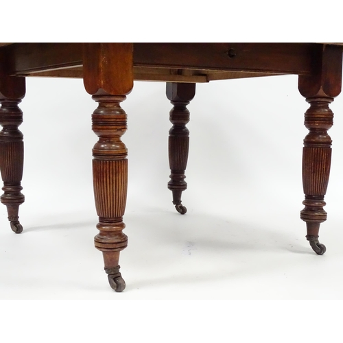 380 - An early 20thC dining table with canted corners and raised on turned tapering legs with reeded decor... 