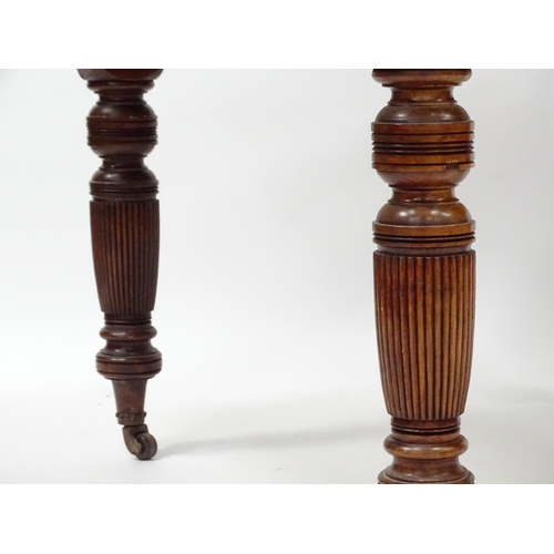 380 - An early 20thC dining table with canted corners and raised on turned tapering legs with reeded decor... 