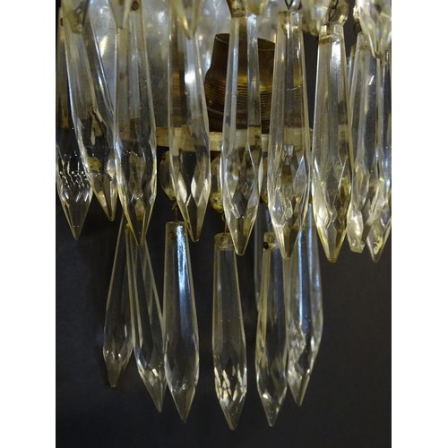 401 - A pair of three tier wall lights with lustre drops and floral and foliate gilt metal detail. Approx.... 