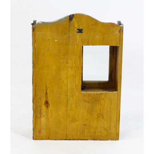 448 - A pine hanging wall cabinet, with two glazed doors above a small rack with a gallery of turned finia... 