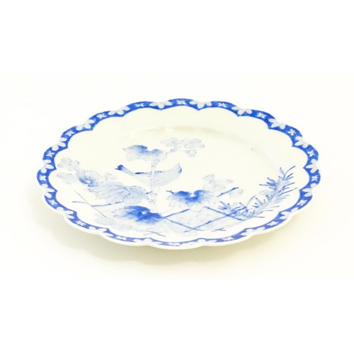 496 - A Japanese blue and white plate with scalloped edge, decorated with a bird perched on a branch with ... 