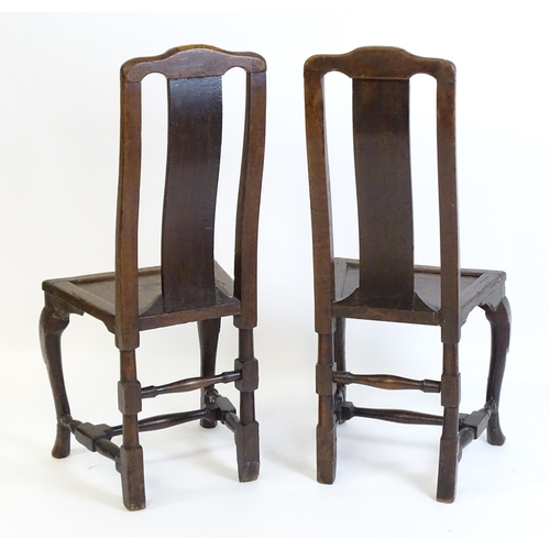 1508A - A pair of early 18thC oak side chairs, with carved top rails decorated with scrolls and floral detai... 