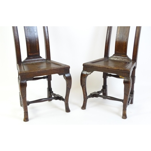 1508A - A pair of early 18thC oak side chairs, with carved top rails decorated with scrolls and floral detai... 