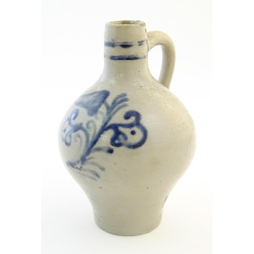 825 - A Continental stoneware vase / jug with bulbous body and single handle, decorated with stylised flor... 