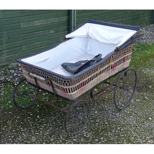 1084 - A large Victorian pram / spinal / invalid carriage. The wicker bassinette body on a four wheel frame... 