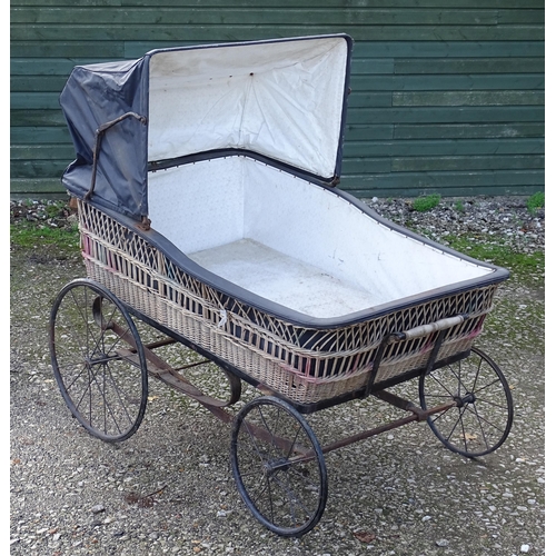 1084 - A large Victorian pram / spinal / invalid carriage. The wicker bassinette body on a four wheel frame... 