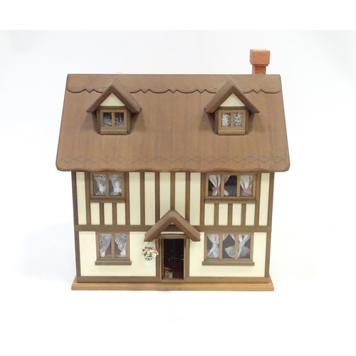 250 - A mid 20thC dolls house, the front and roof opening to reveal six rooms containing assorted dolls ho... 