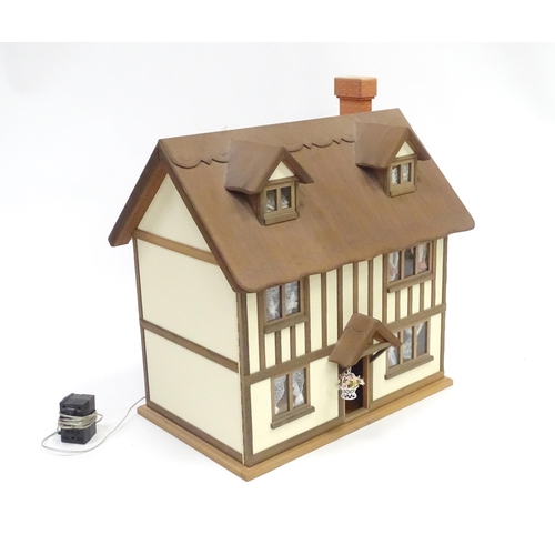 250 - A mid 20thC dolls house, the front and roof opening to reveal six rooms containing assorted dolls ho... 