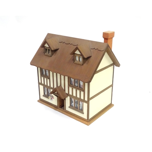 250 - A mid 20thC dolls house, the front and roof opening to reveal six rooms containing assorted dolls ho... 