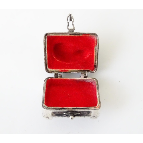 519 - A white metal pill box of oblong form surmounted by a cat. Approx. 1 3/8