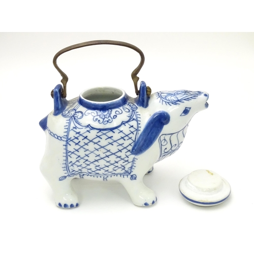 129 - A novelty blue and white teapot modelled as a mythical animal. Together with an Oriental blue and wh... 