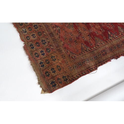 16 - Carpet / Rug : A red ground rug with geometric motifs and banded borders, approx 60