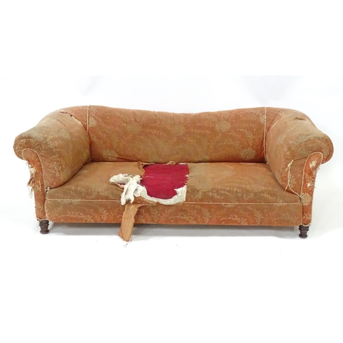 256 - A 19thC two seater Chesterfield sofa, with scrolled arms and standing on four carved feet, approx 75... 