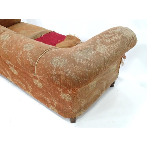 256 - A 19thC two seater Chesterfield sofa, with scrolled arms and standing on four carved feet, approx 75... 