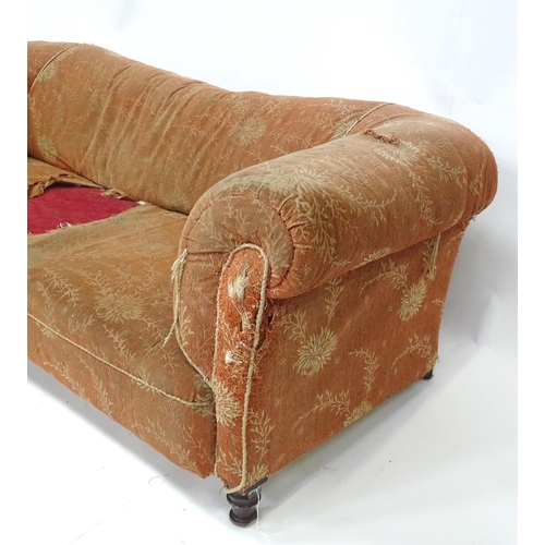 256 - A 19thC two seater Chesterfield sofa, with scrolled arms and standing on four carved feet, approx 75... 