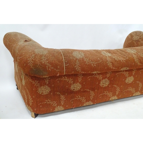 256 - A 19thC two seater Chesterfield sofa, with scrolled arms and standing on four carved feet, approx 75... 