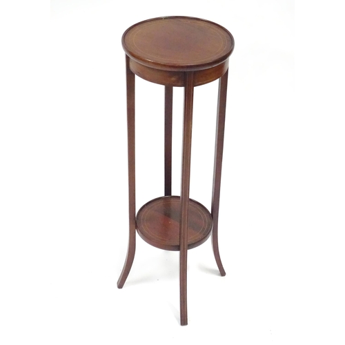 334 - An Edwardian mahogany jardiniere stand, with two circular tiers, decorated with boxwood stringing an... 