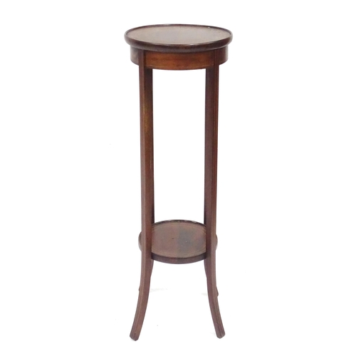 334 - An Edwardian mahogany jardiniere stand, with two circular tiers, decorated with boxwood stringing an... 