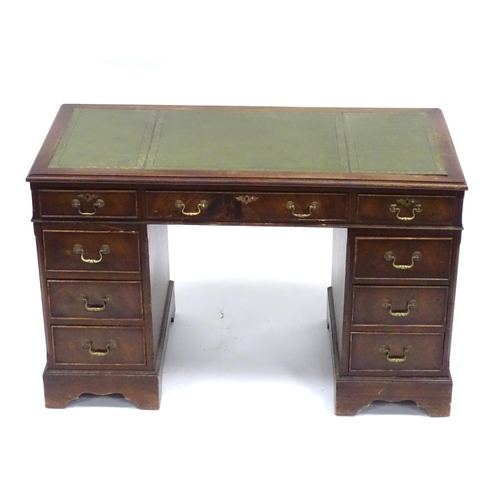 335 - A 20thC mahogany pedestal desk with nine drawers, the top with green tooled leather insert, the pede... 