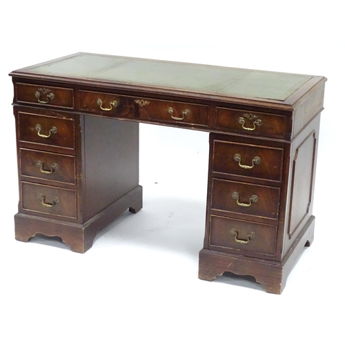 335 - A 20thC mahogany pedestal desk with nine drawers, the top with green tooled leather insert, the pede... 