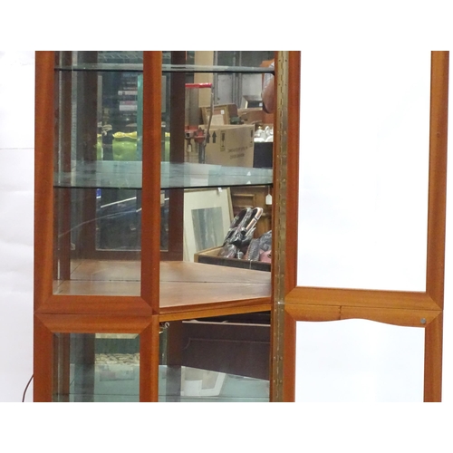 344 - A modern glazed corner display unit by James H Sutcliffe & Son, of teak construction with glass shel... 