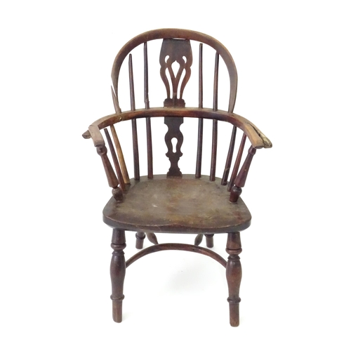 345 - A 19thC Windsor child's armchair with a double-bow stick back and shaped, pierced splat. Standing on... 