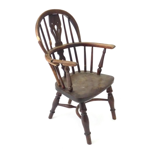 345 - A 19thC Windsor child's armchair with a double-bow stick back and shaped, pierced splat. Standing on... 