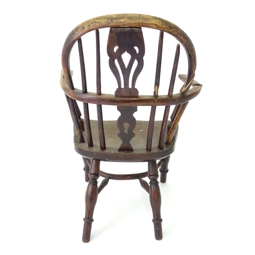 345 - A 19thC Windsor child's armchair with a double-bow stick back and shaped, pierced splat. Standing on... 