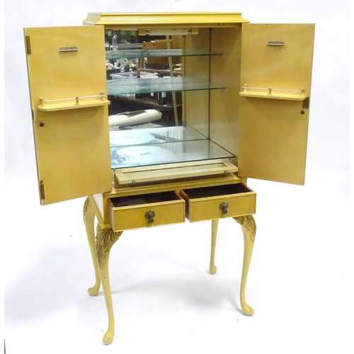 347 - A mid 20thC cocktail cabinet, the exterior with clouded yellow finish and oriental mounts. The upper... 