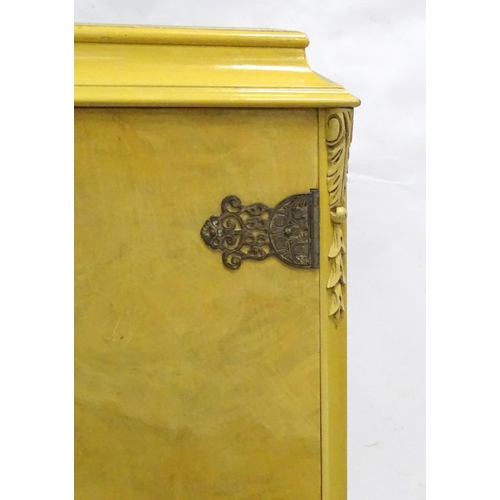 347 - A mid 20thC cocktail cabinet, the exterior with clouded yellow finish and oriental mounts. The upper... 