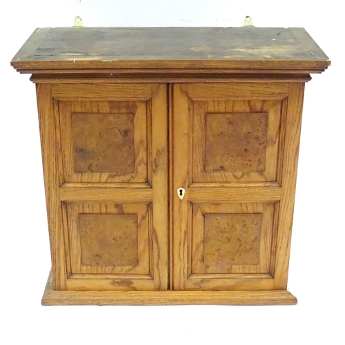 348 - A early 20thC wall cabinet, of ash construction with applied burr walnut panels to the doors. The in... 