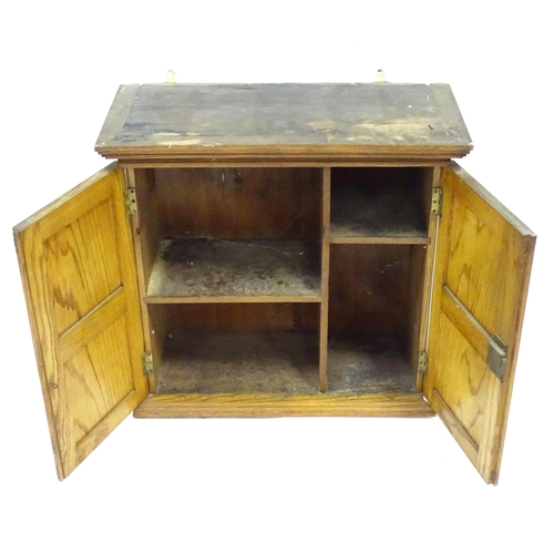 348 - A early 20thC wall cabinet, of ash construction with applied burr walnut panels to the doors. The in... 