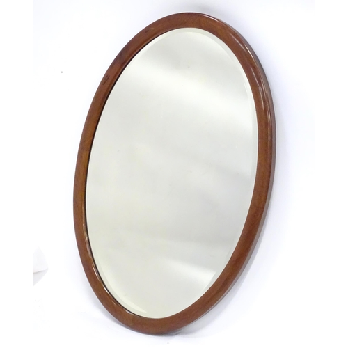 396 - An oval mahogany wall mirror. Approx. 22