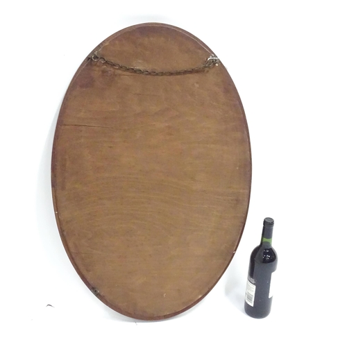 396 - An oval mahogany wall mirror. Approx. 22