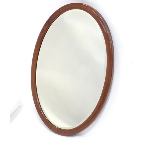 396 - An oval mahogany wall mirror. Approx. 22