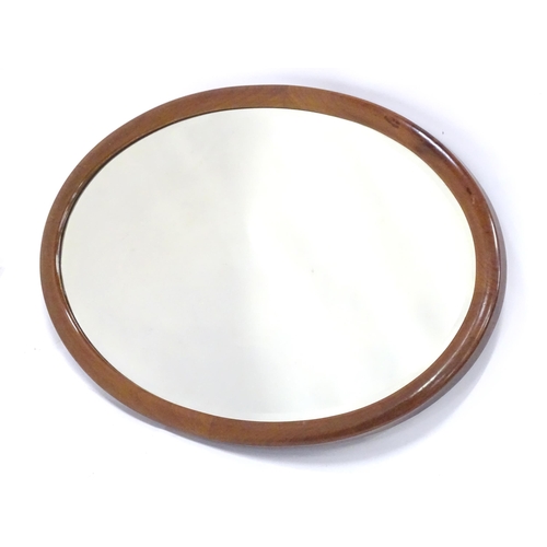 396 - An oval mahogany wall mirror. Approx. 22