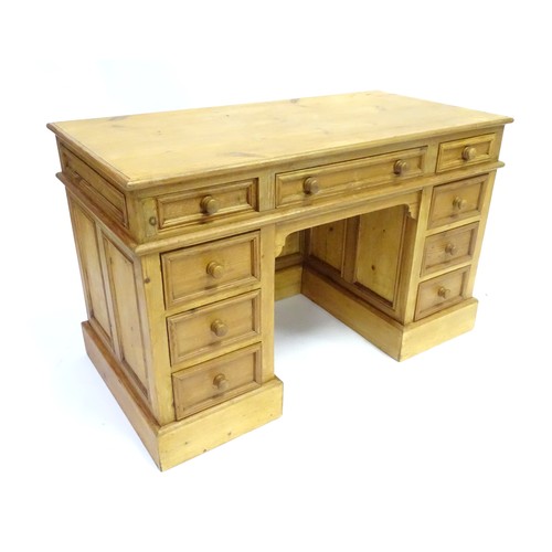 282 - A 20thC pine pedestal desk with nine drawers and enclosed back, approx 48