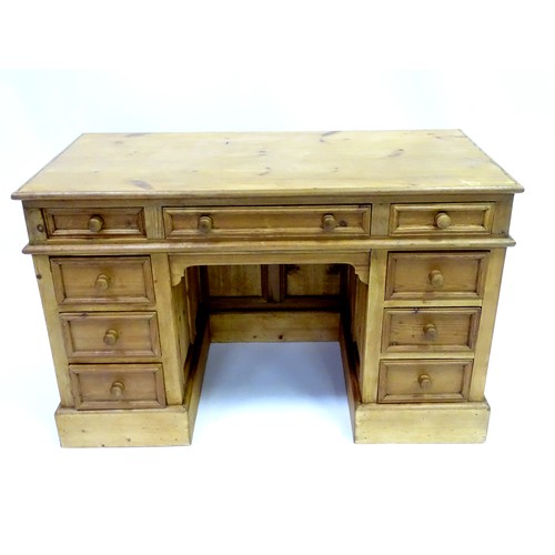 282 - A 20thC pine pedestal desk with nine drawers and enclosed back, approx 48