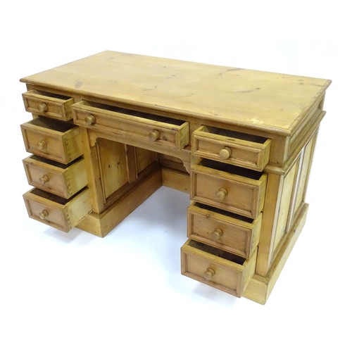 282 - A 20thC pine pedestal desk with nine drawers and enclosed back, approx 48