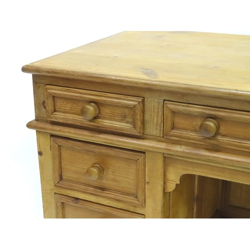 282 - A 20thC pine pedestal desk with nine drawers and enclosed back, approx 48