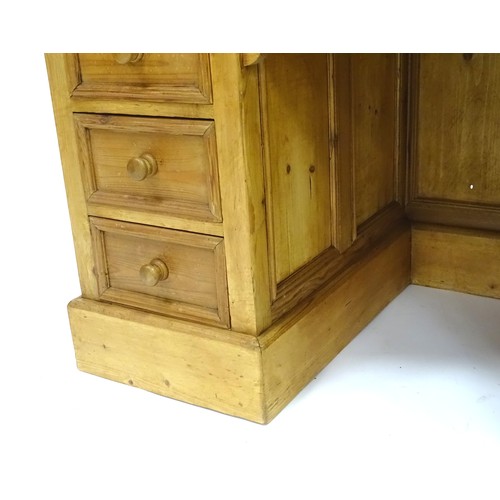 282 - A 20thC pine pedestal desk with nine drawers and enclosed back, approx 48