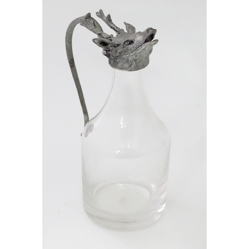 820 - A glass whiskey water jug / noggin with stags head detail to top. Approx 6