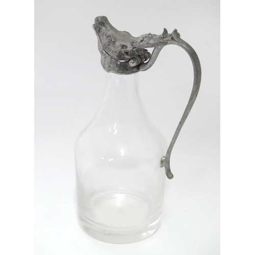 820 - A glass whiskey water jug / noggin with stags head detail to top. Approx 6