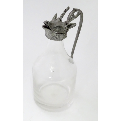 820 - A glass whiskey water jug / noggin with stags head detail to top. Approx 6