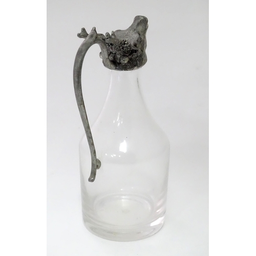 820 - A glass whiskey water jug / noggin with stags head detail to top. Approx 6