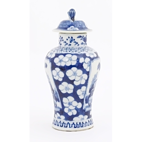 11 - A Chinese blue and white vase and cover with panelled decoration depicting figures in a landscape bo... 